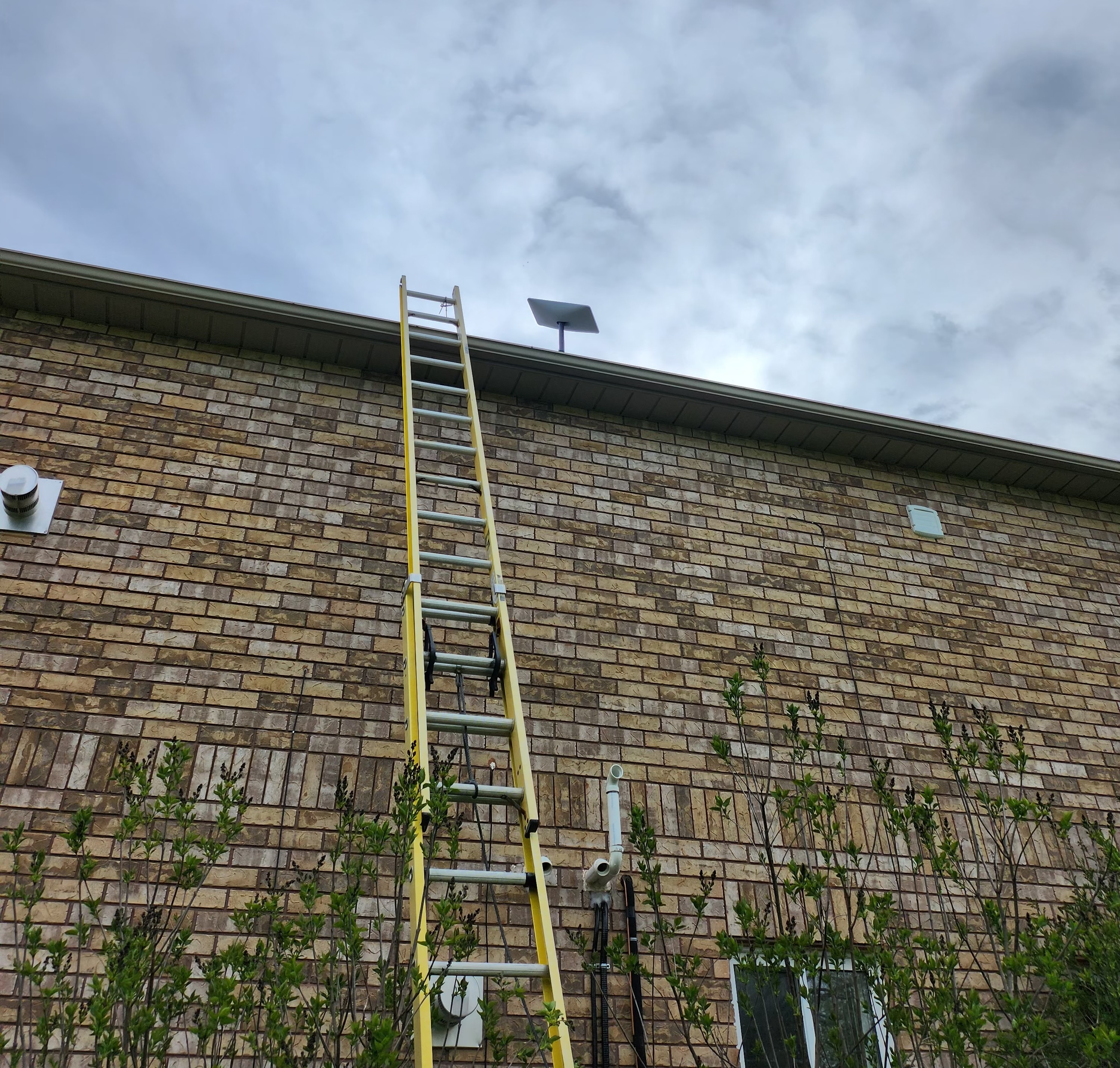 starlink j-arm installation on a large brick wall